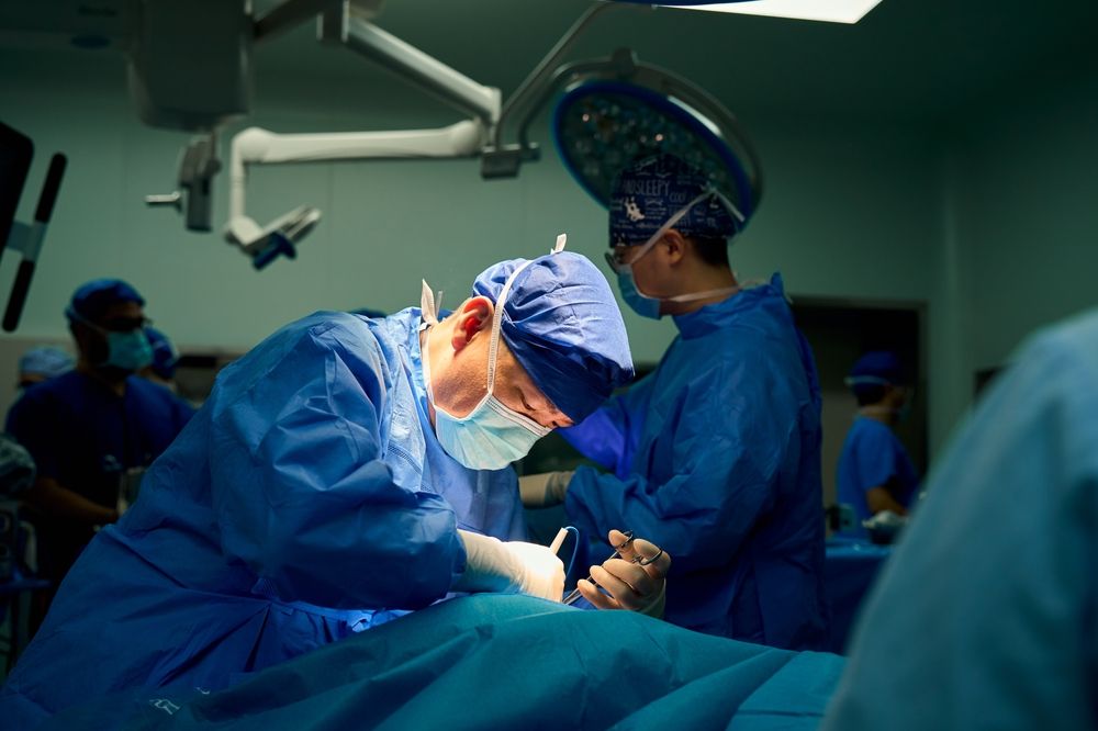 Two surgeons performing a procedure in an operating theatre