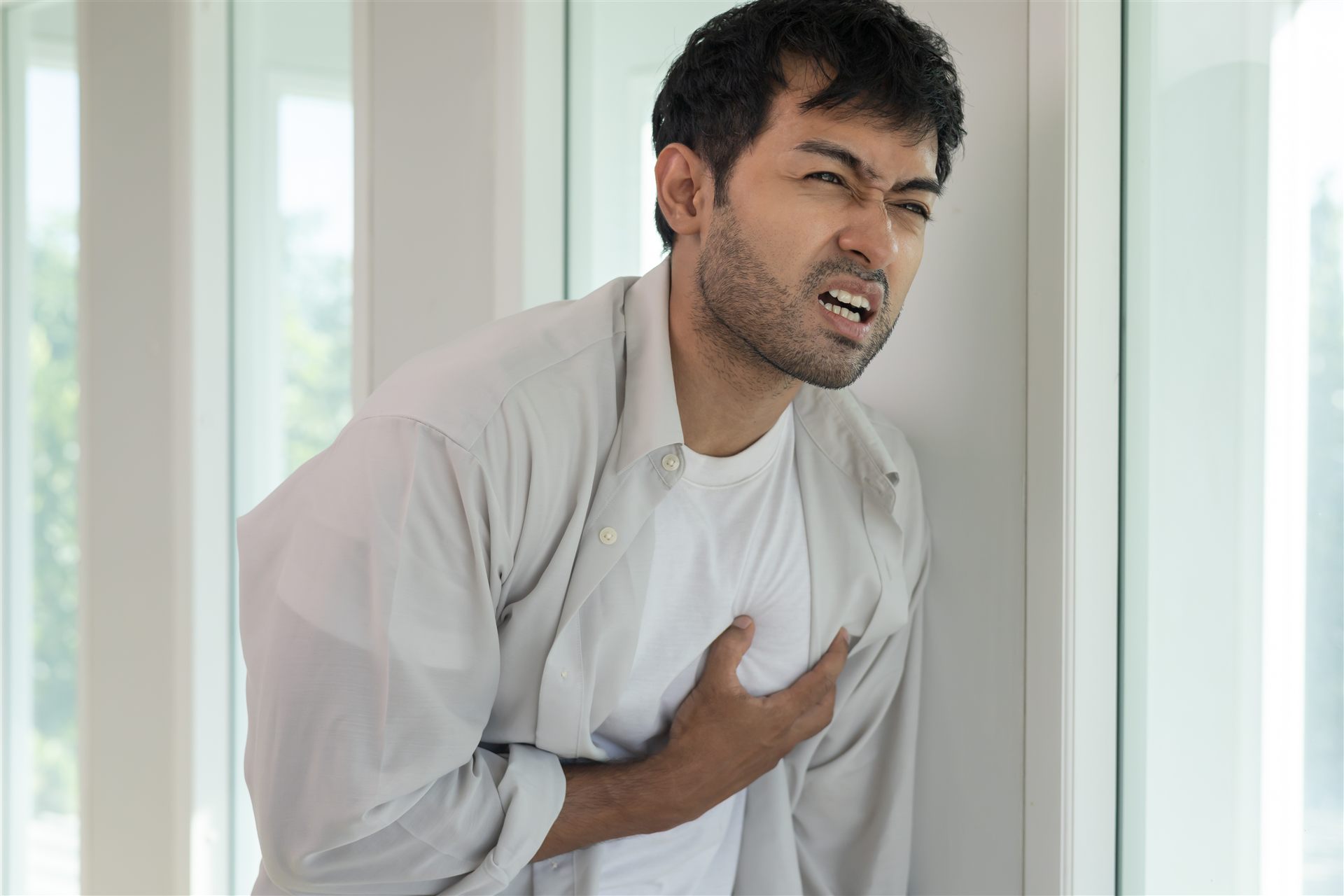 A man clutching his chest in discomfort
